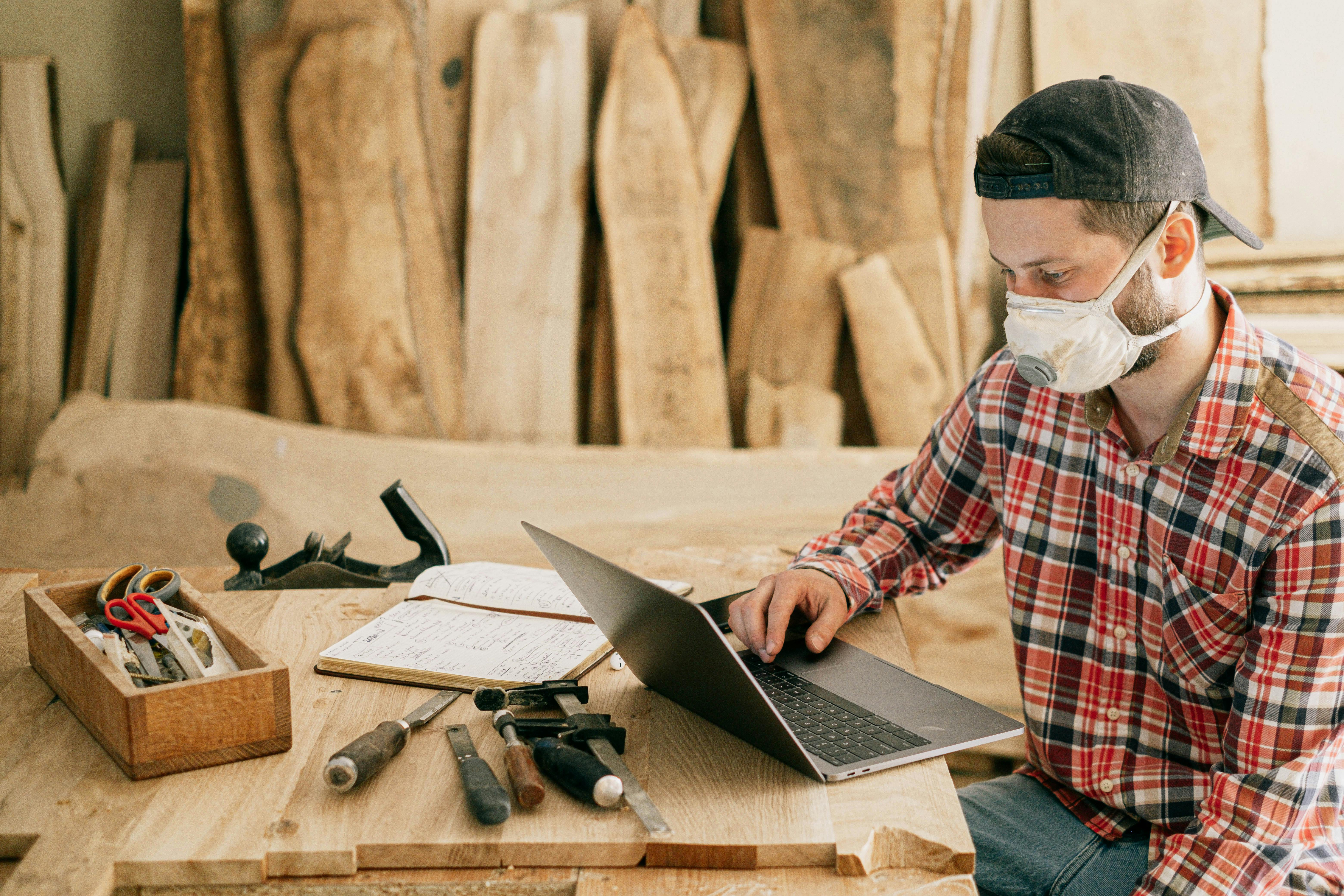 Handyman works on his laptop.