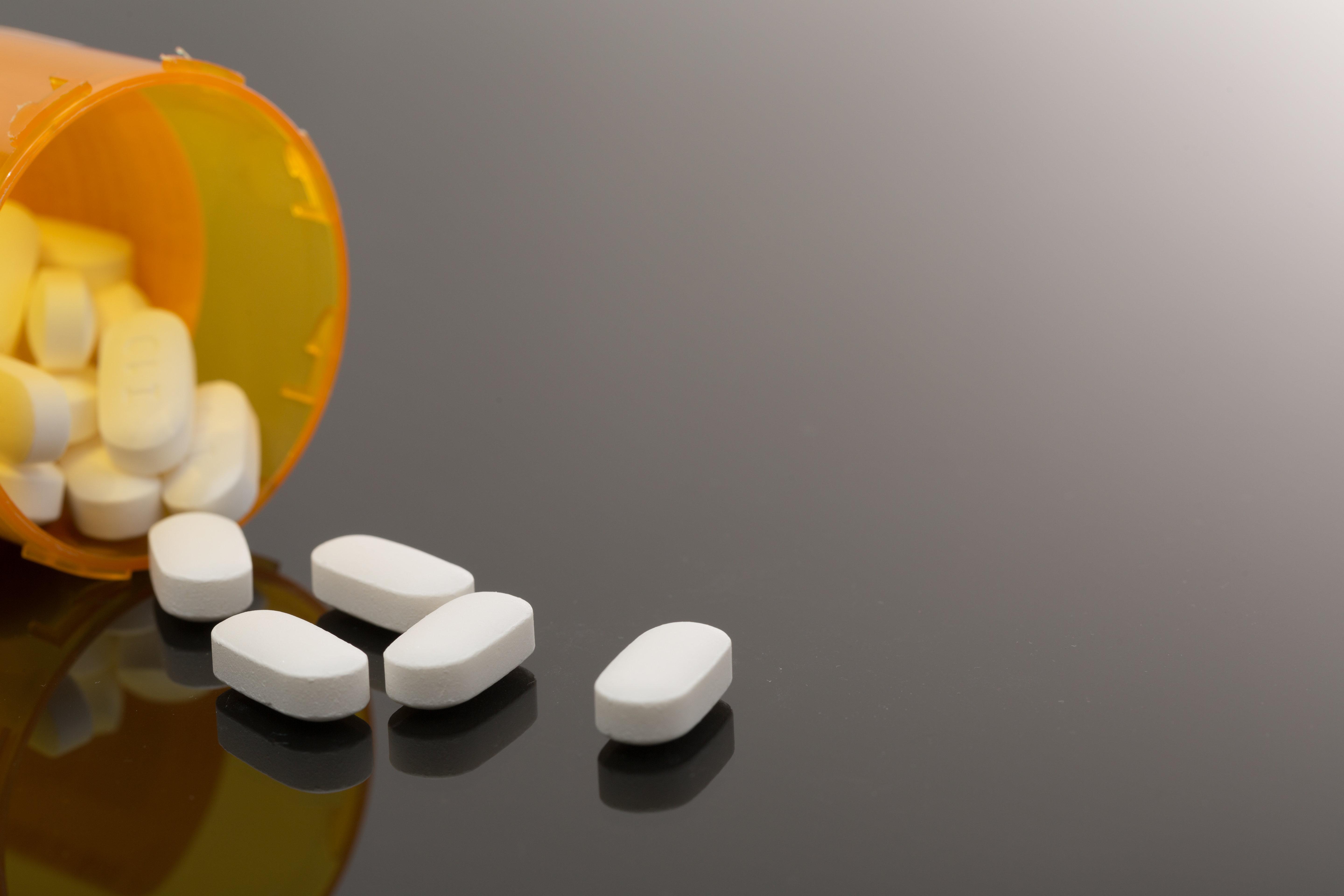 Pills spilling out of a prescription drug bottle