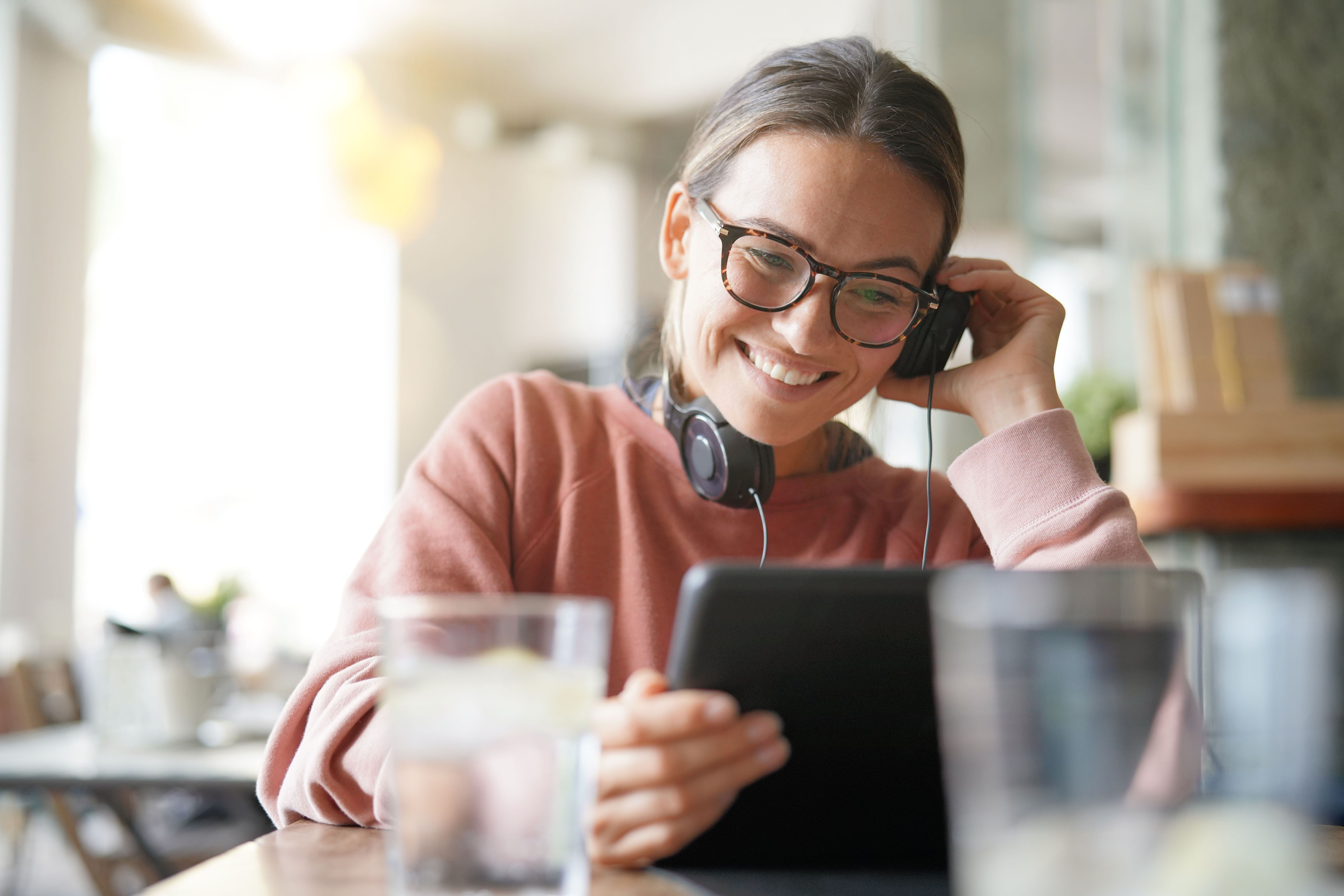 Millennial woman looking at an iPad with headphones on