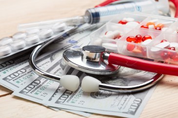 Money, medical supplies and a pill box on a table