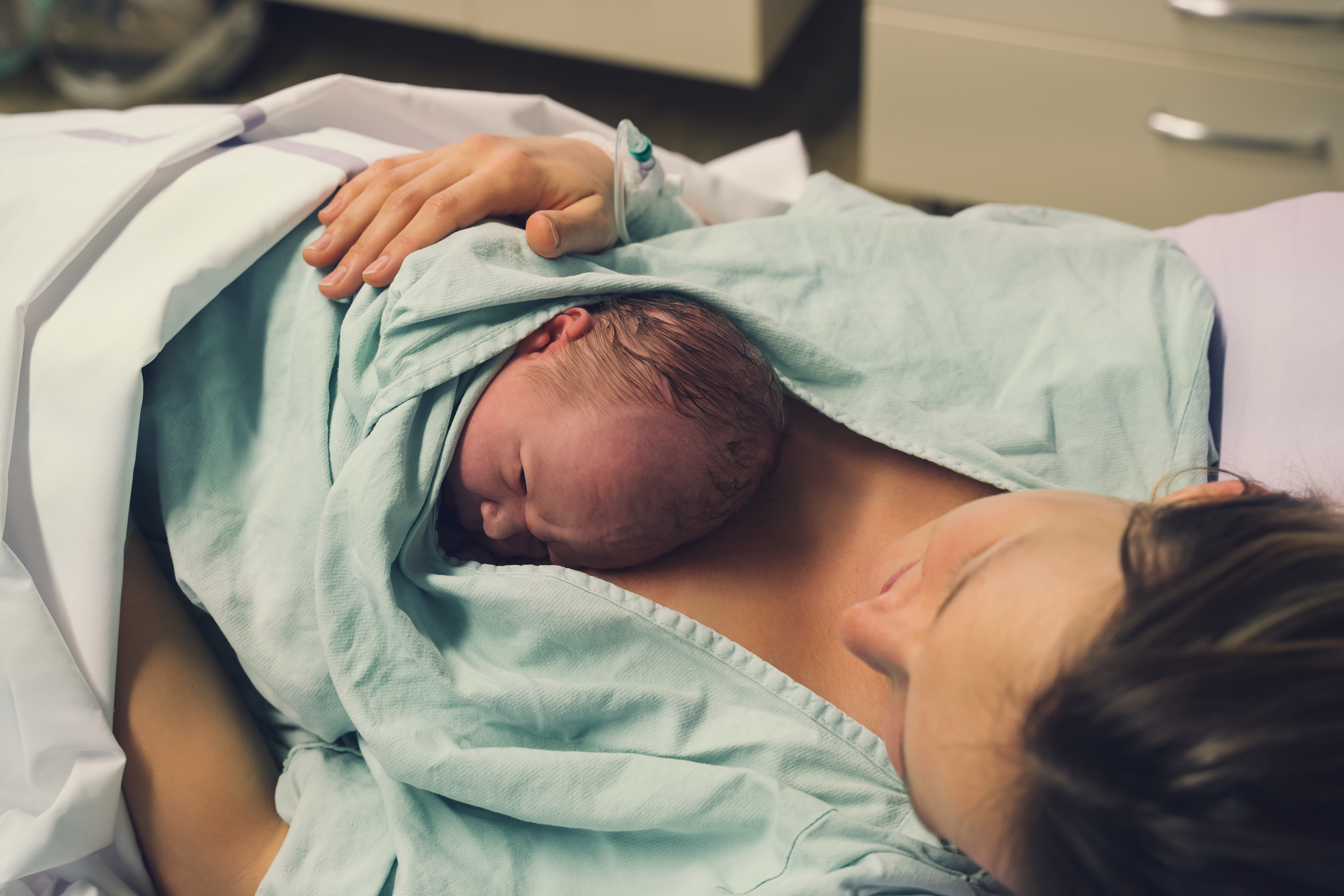 Woman holding her newborn baby after giving birth
