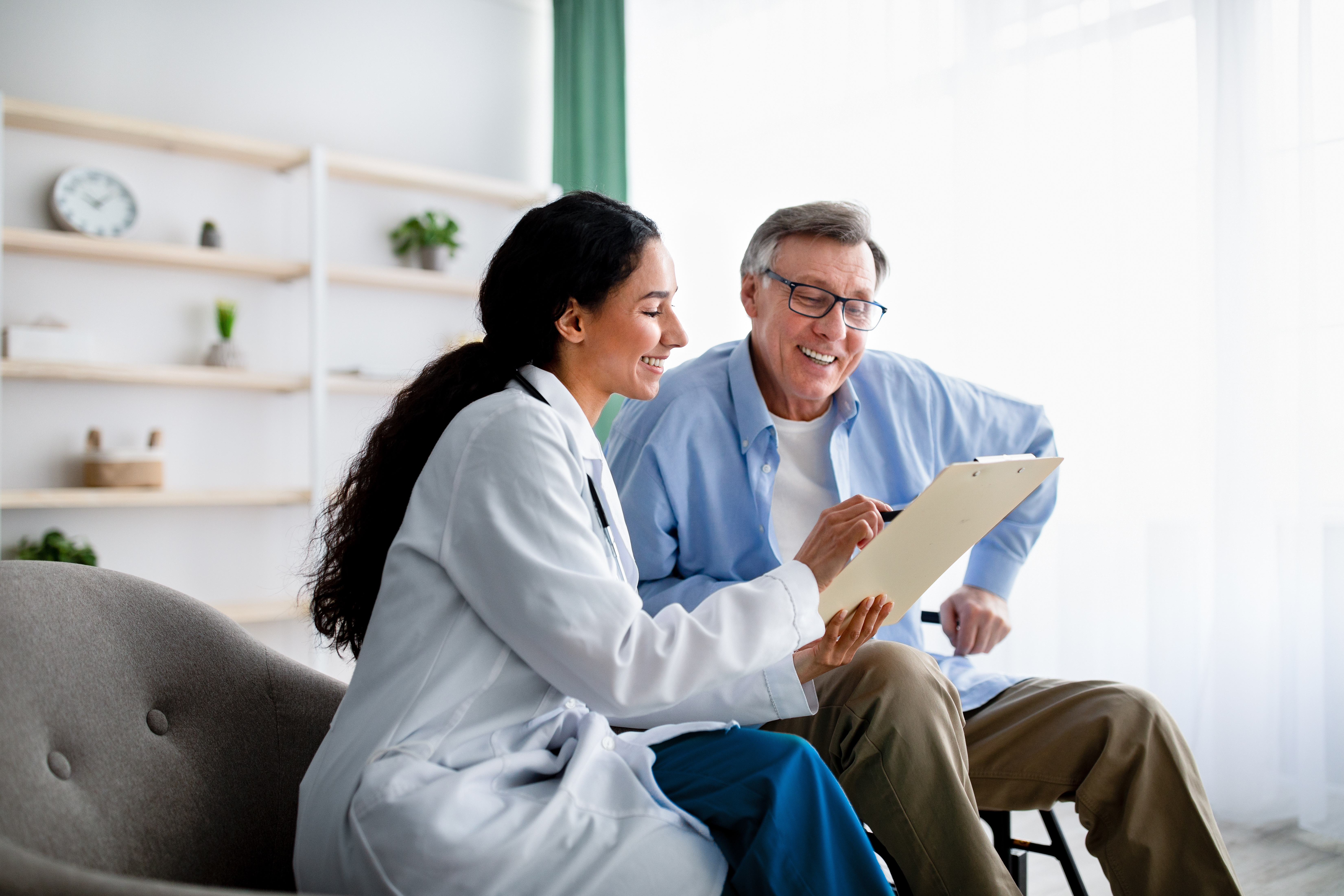 Man sitting with female doctor going over medical information