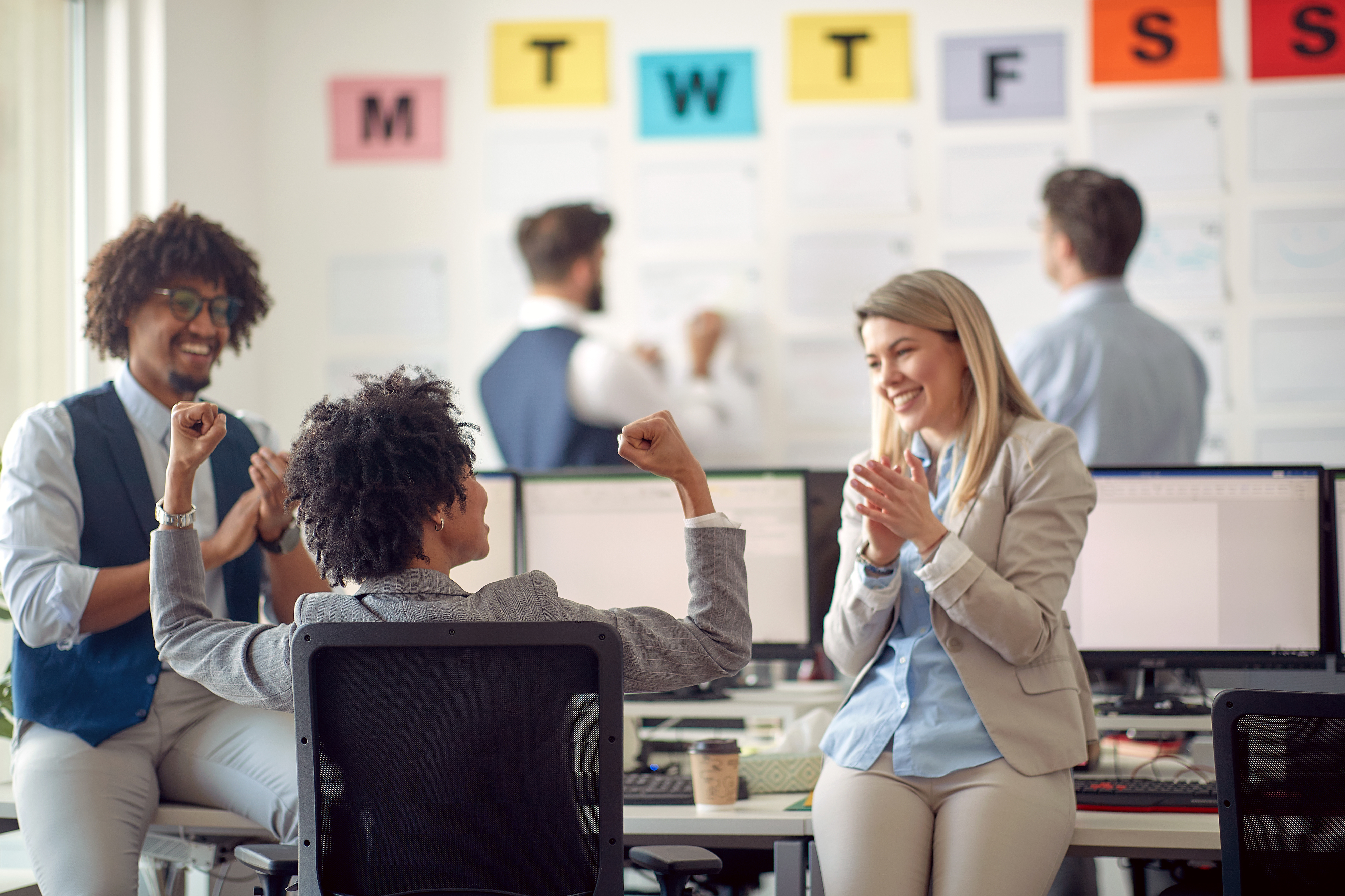 Group of employees talking at desk
