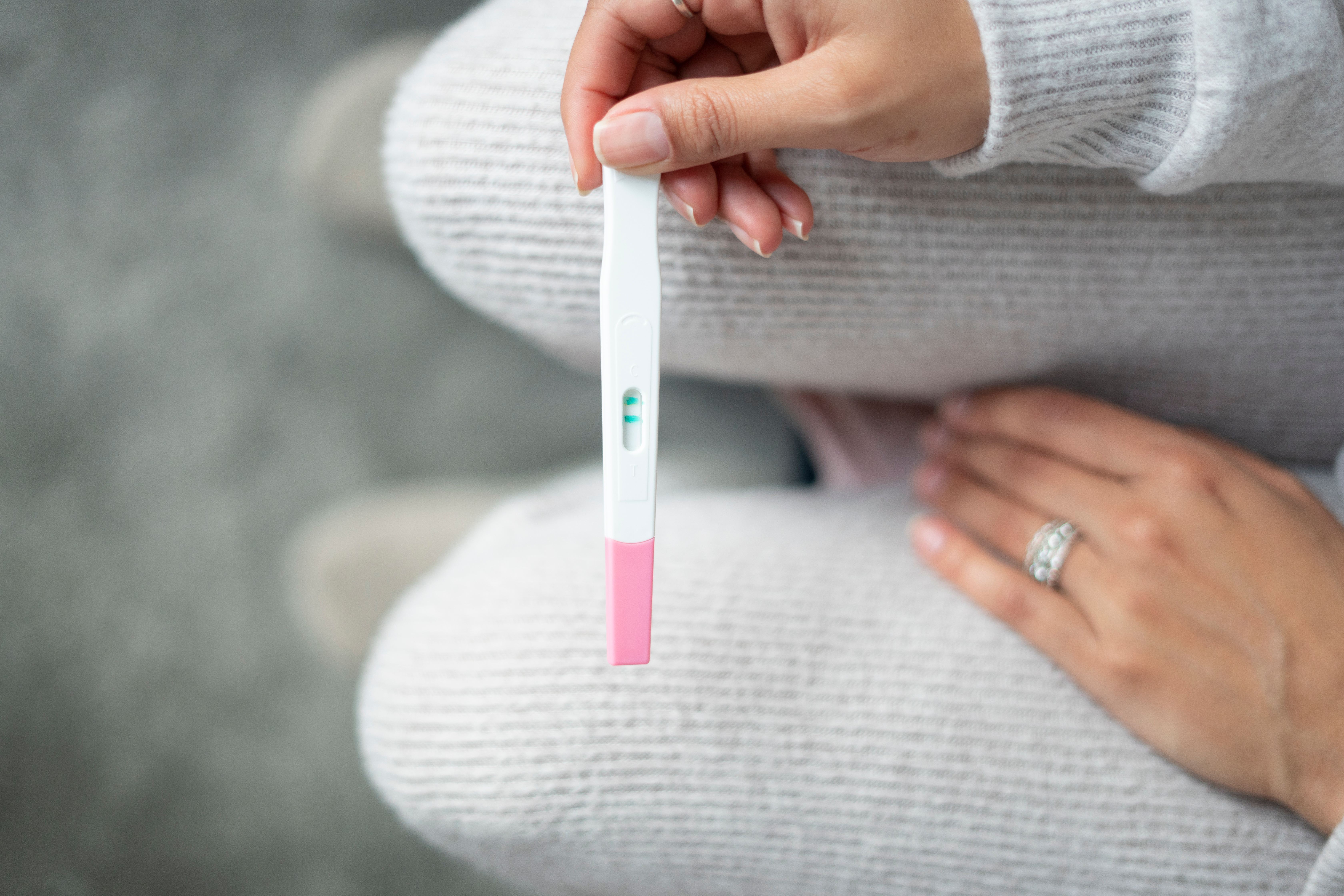 Woman looking down at a pregnancy test