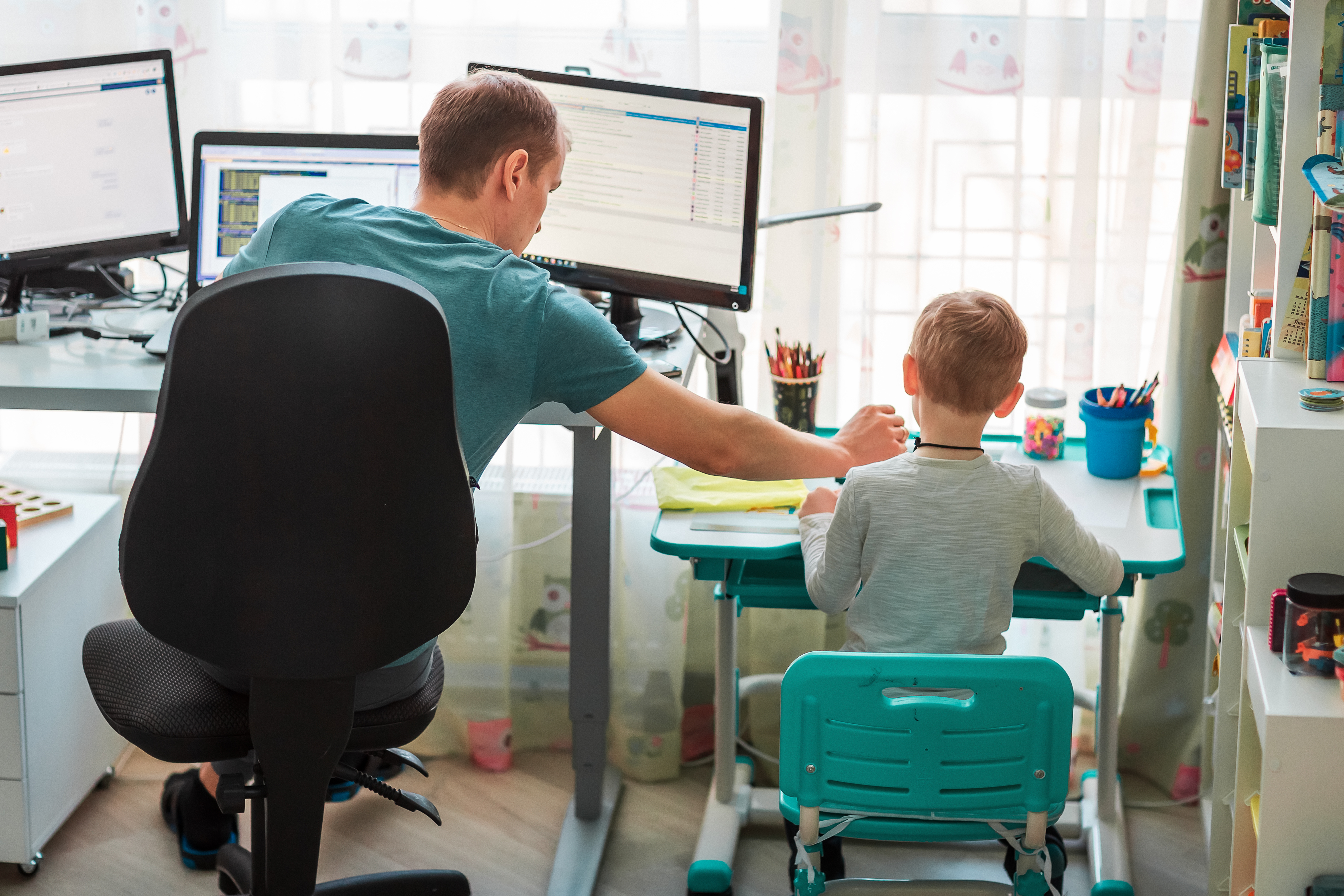 Dad and son sitting next to each other working