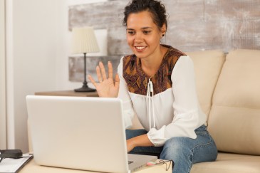 Woman waving to the camera on a job interview