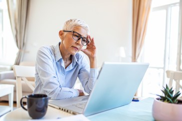 Older woman in front of her computer looking concerned