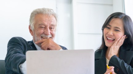 Old and young employee looking at a computer screen