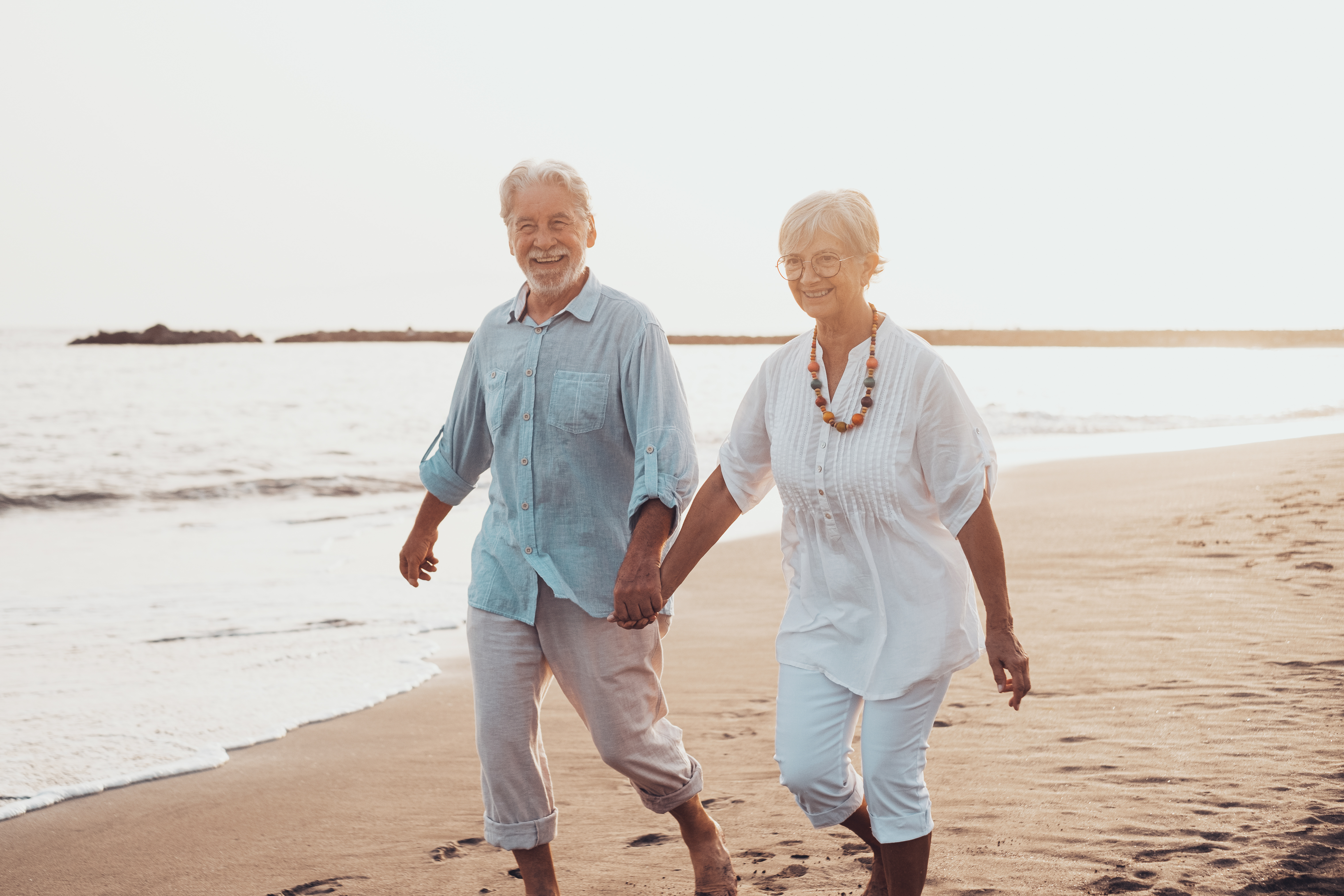 Older couple walking on the beach