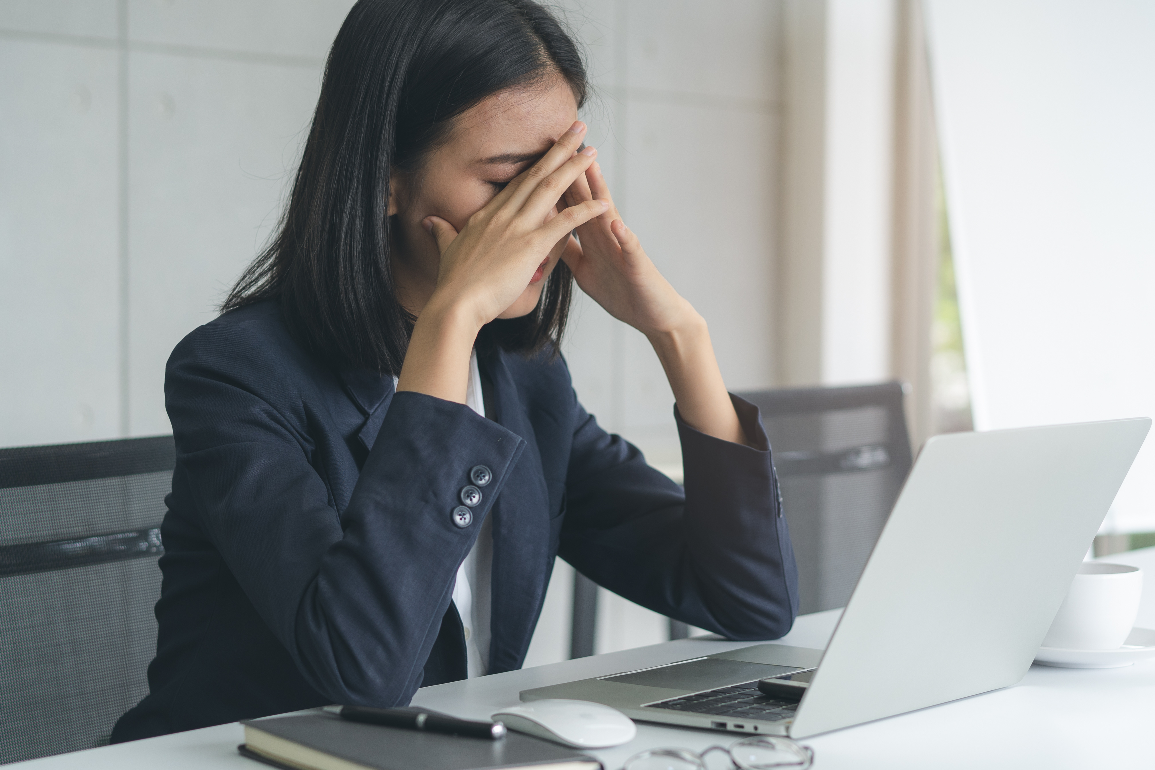 A woman looking stressed in front of her computer