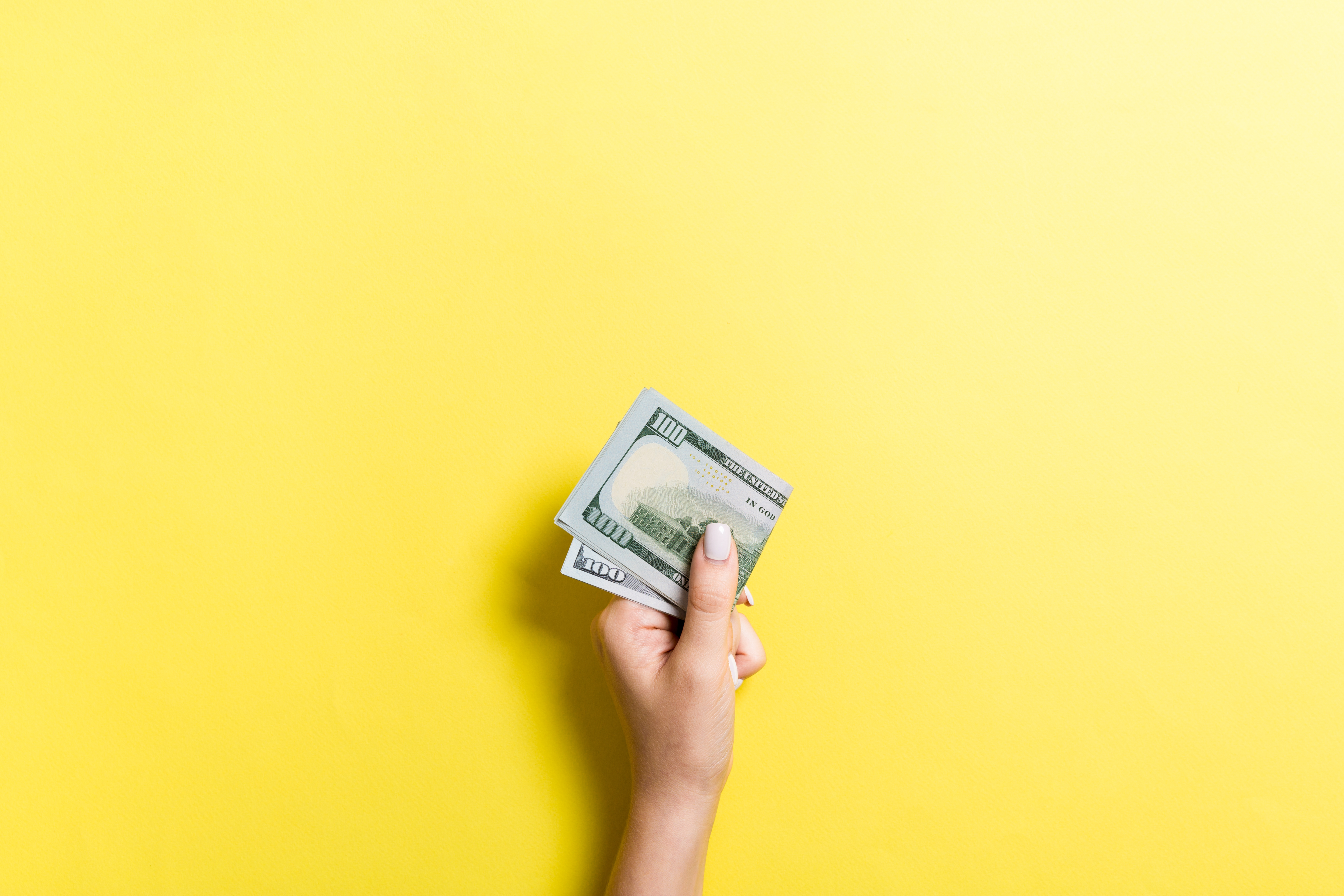 Hand holding $100 bill