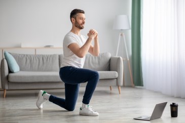 Man stretching with computer open; online fitness