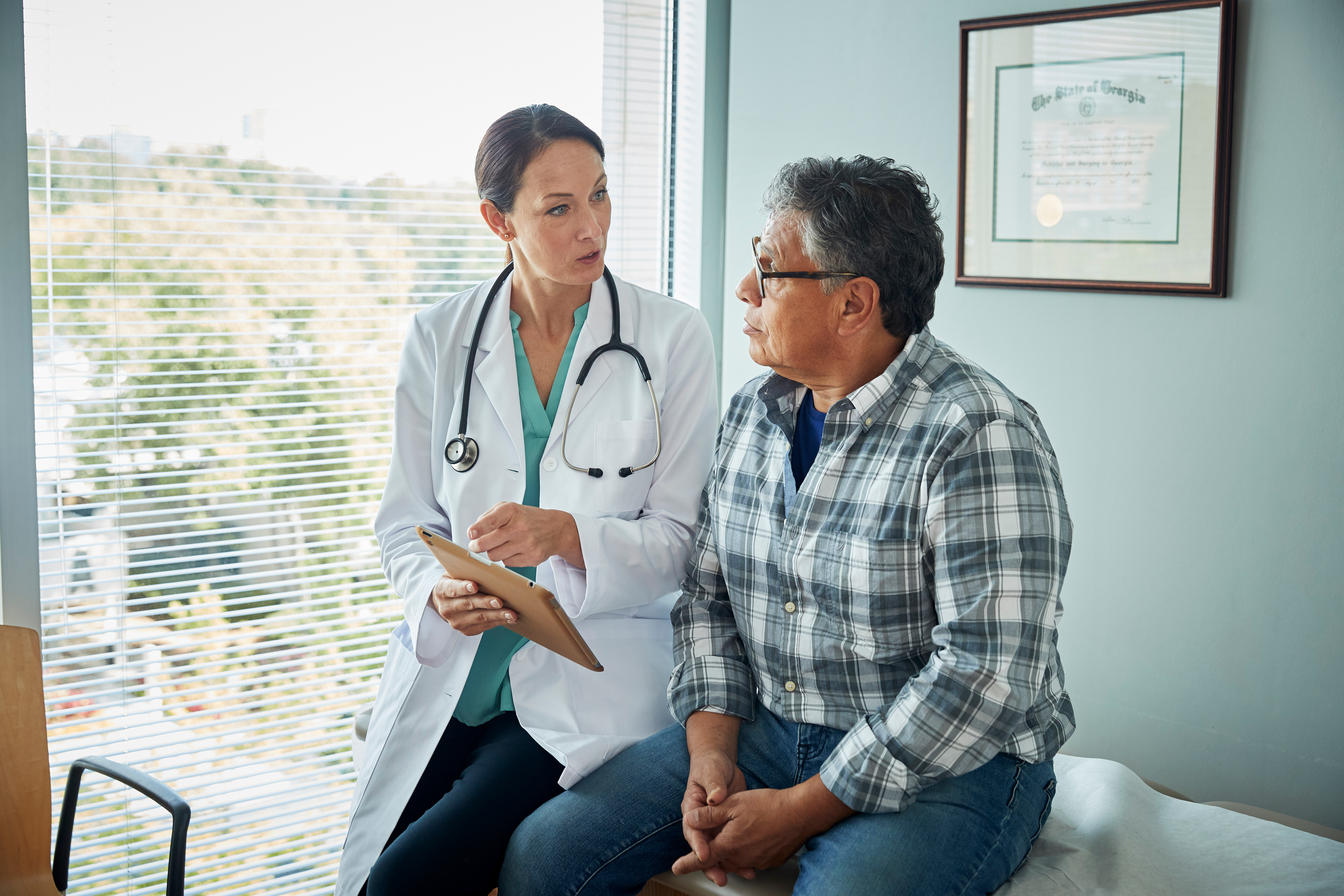 Female doctor talking with middle-aged male patient