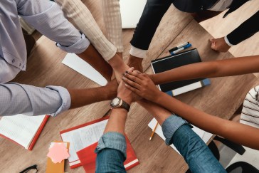 Many people's hands together; employees working together