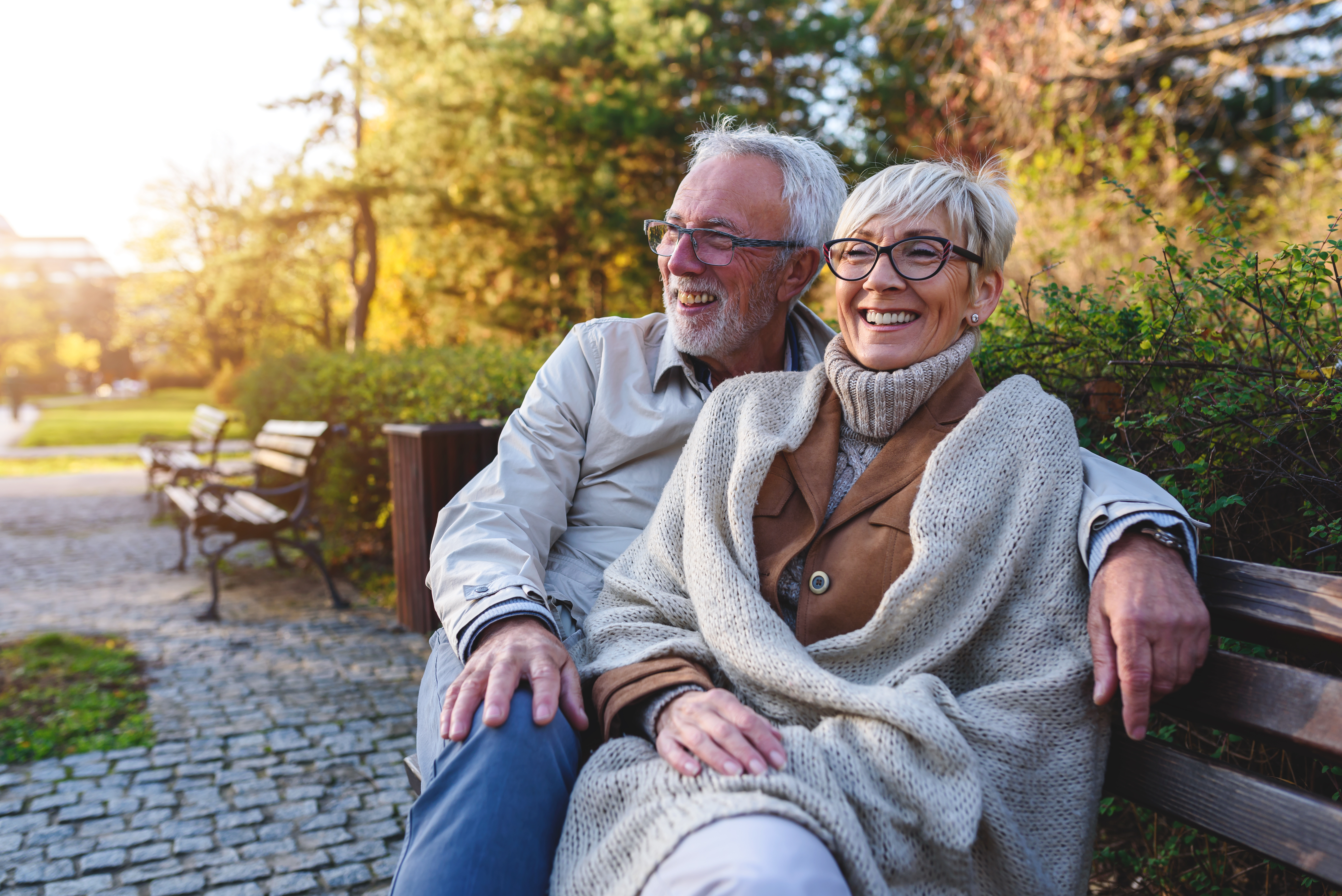 Older couples sitting on bench smiling relaxing