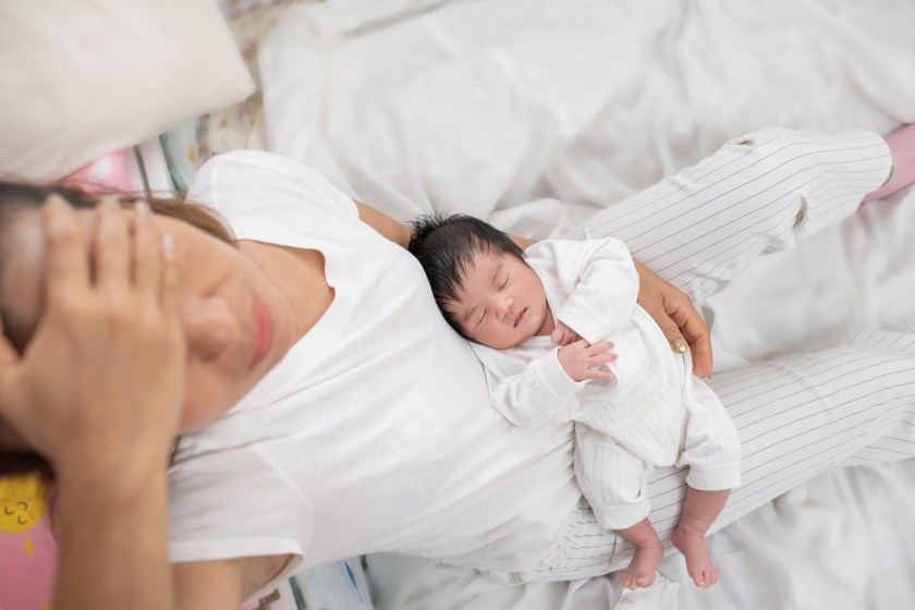Woman looking stressed while holding her baby