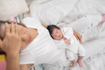 Woman looking stressed while holding her baby