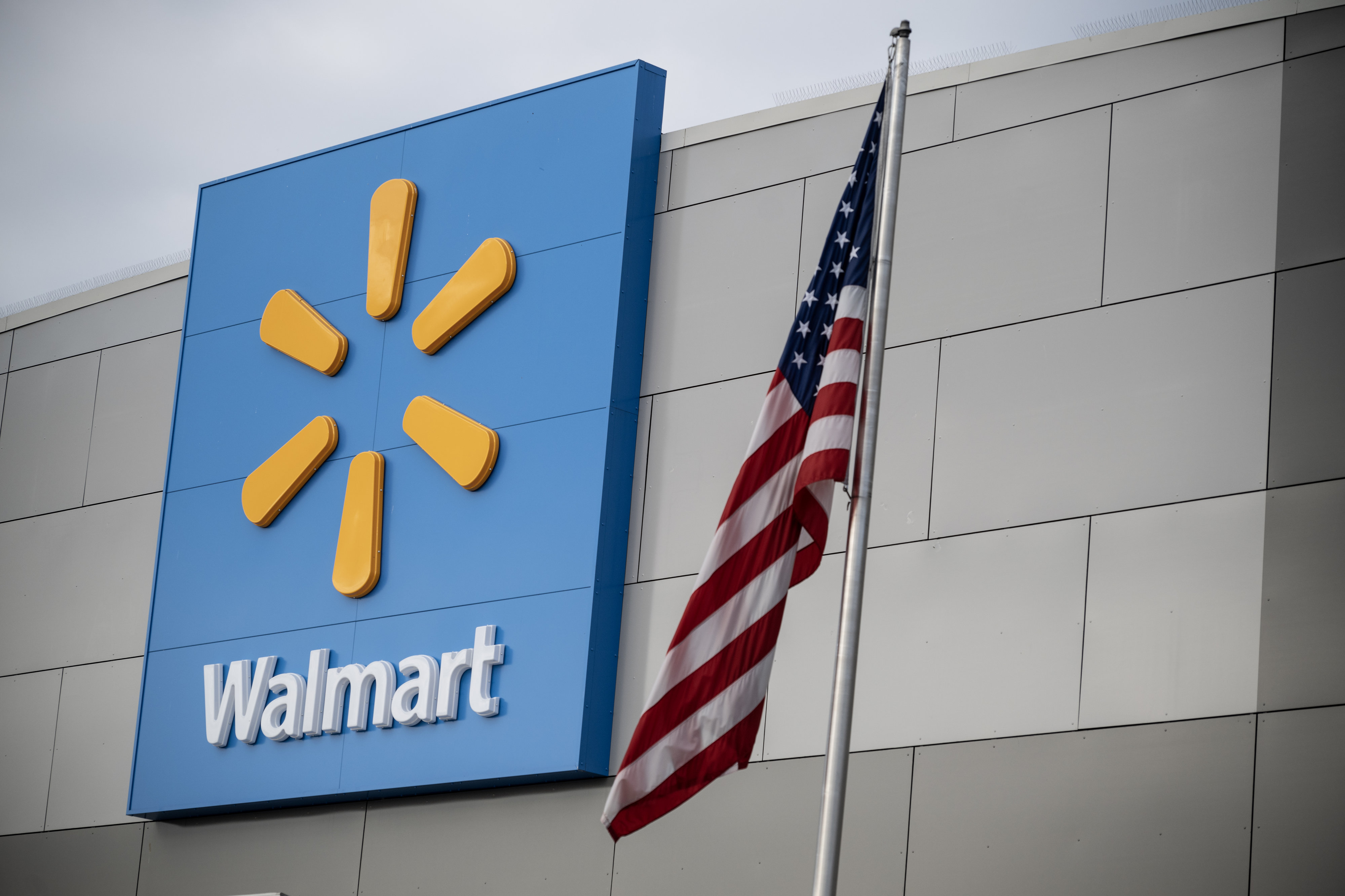 Walmart storefront with U.S. flag flying outside of it.