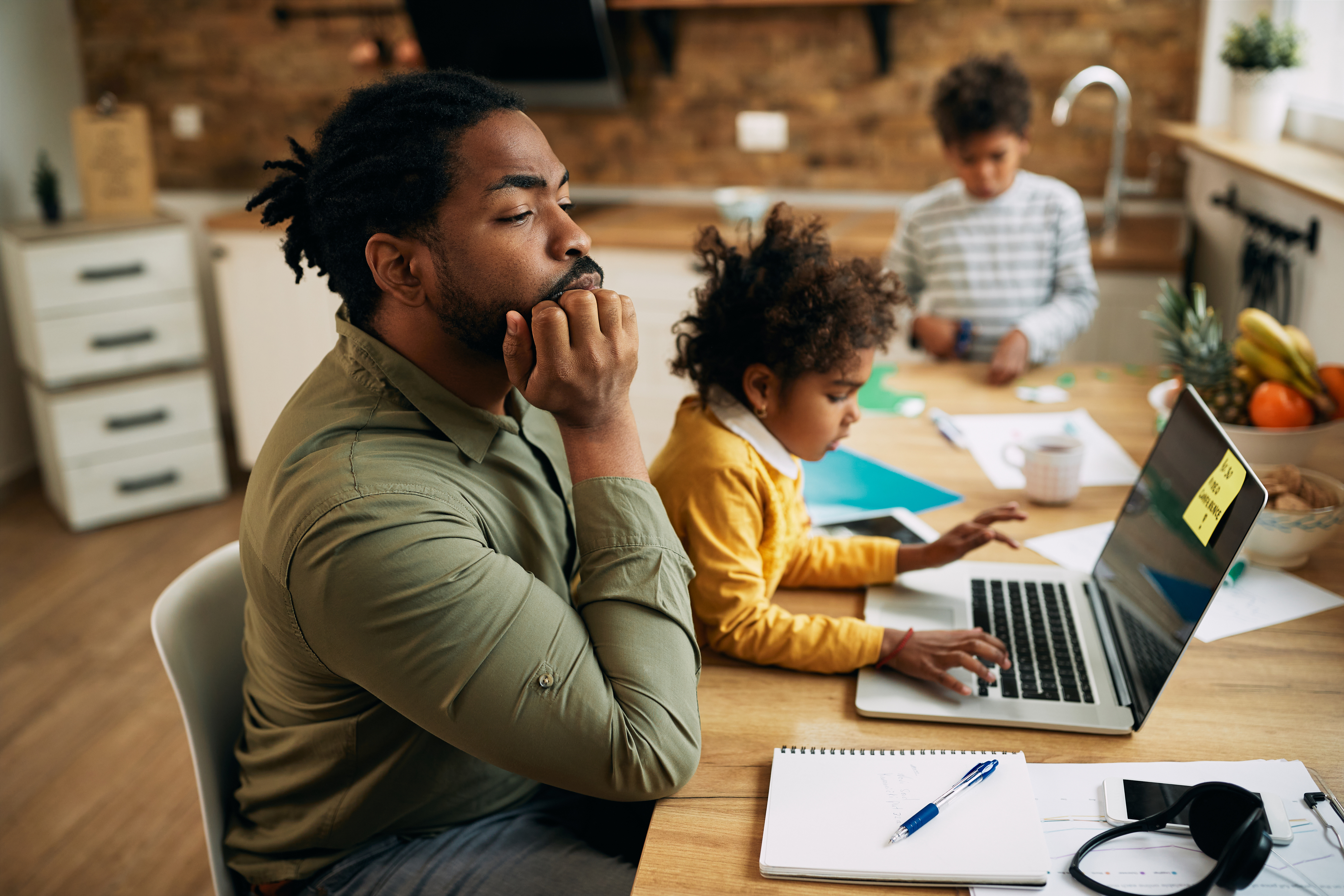 Father working at home office with child in lap concentrating