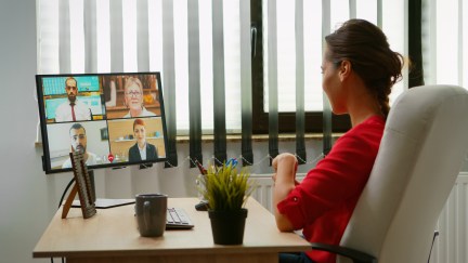 Woman sitting at desk on video meeting call with coworkers