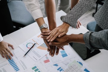 Group of employee hands on top of each other; diverse