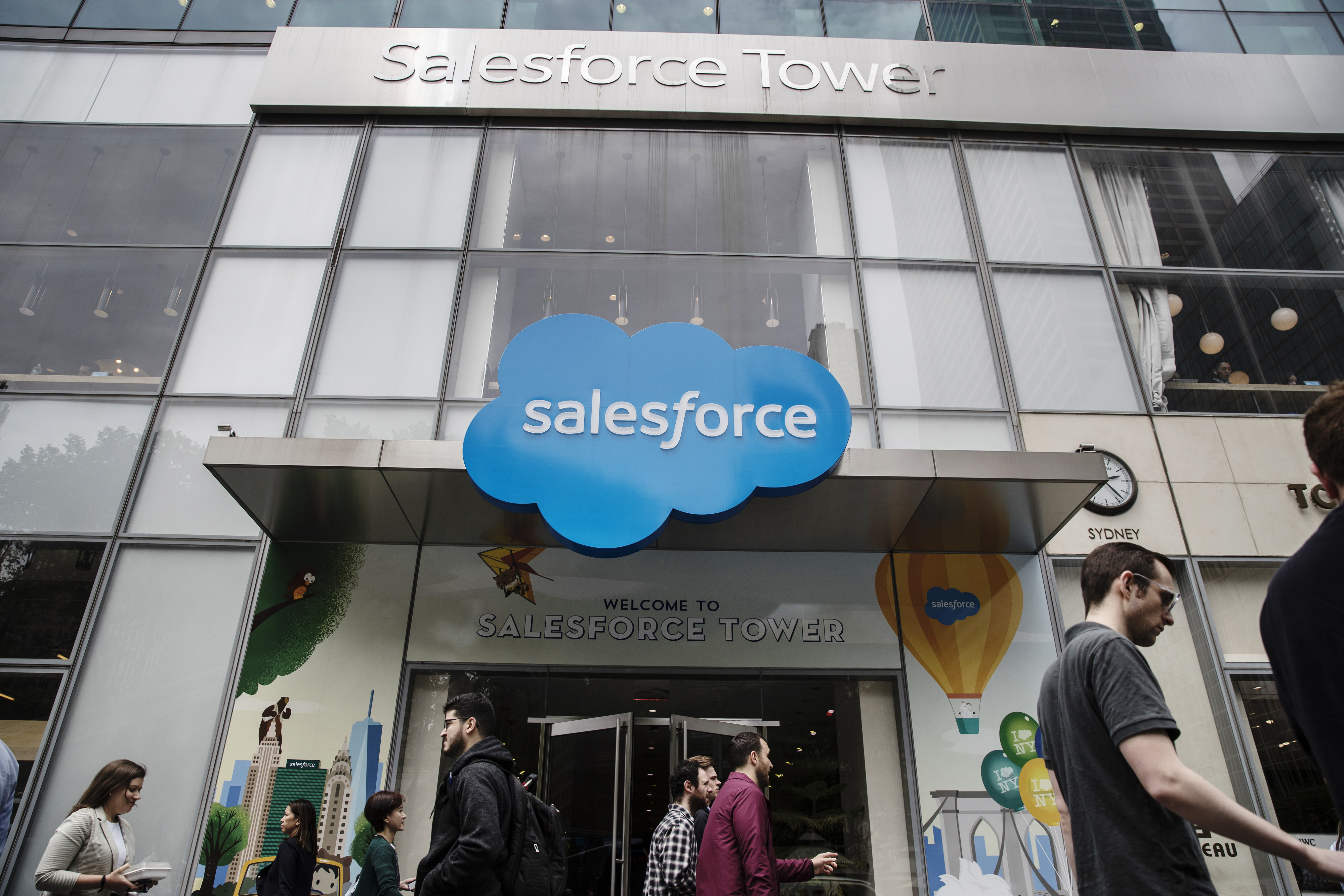 The entrance of the Salesforce Tower; people are walking past in.