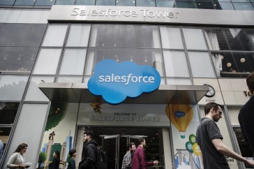 The entrance of the Salesforce Tower; people are walking past in.
