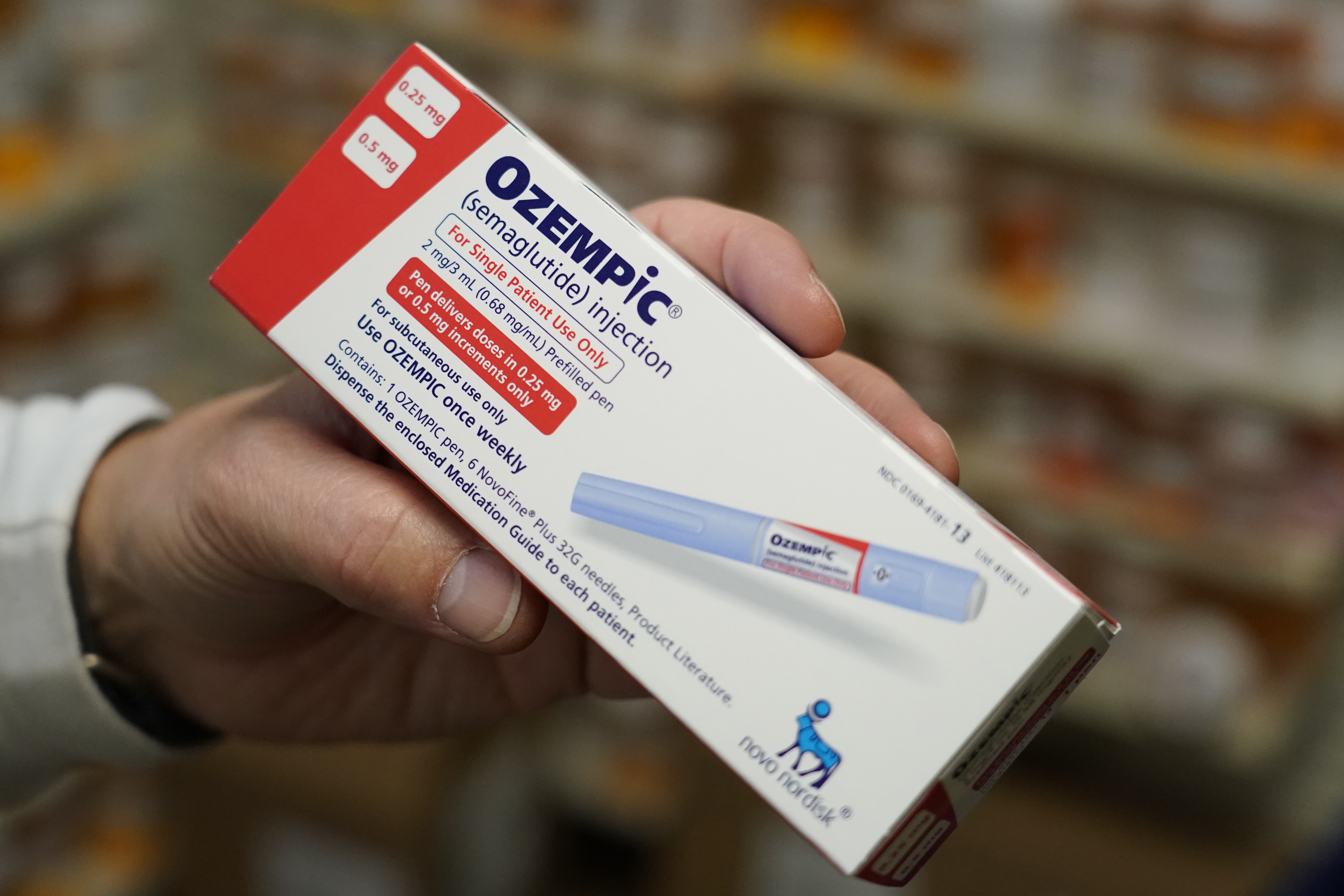 A person holding a box of Ozempic.