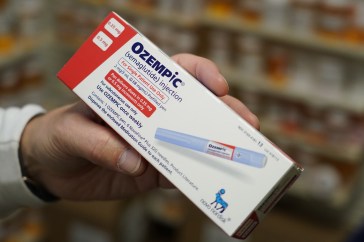 A person holding a box of Ozempic.