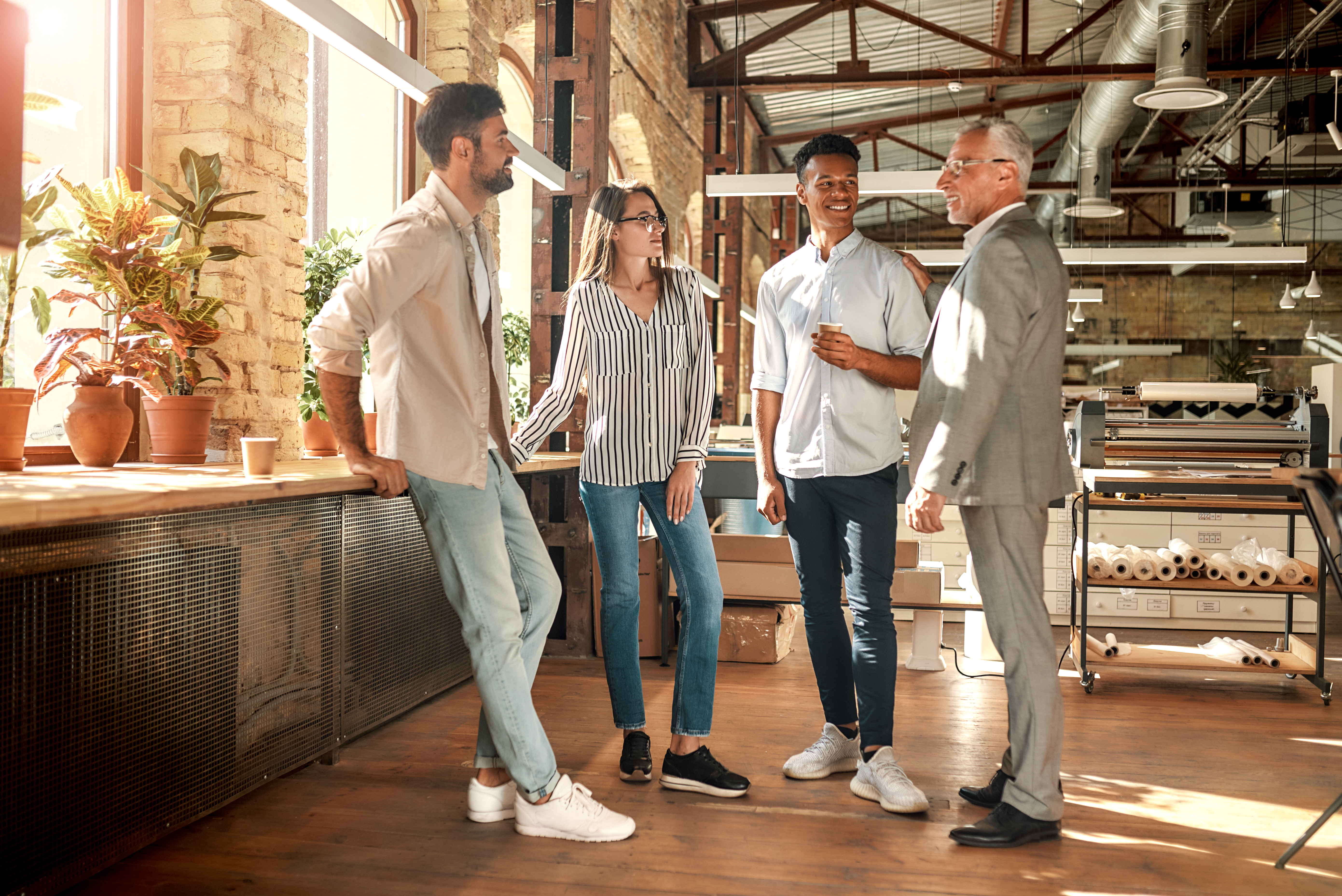 Group of employees standing together, talking, smiling