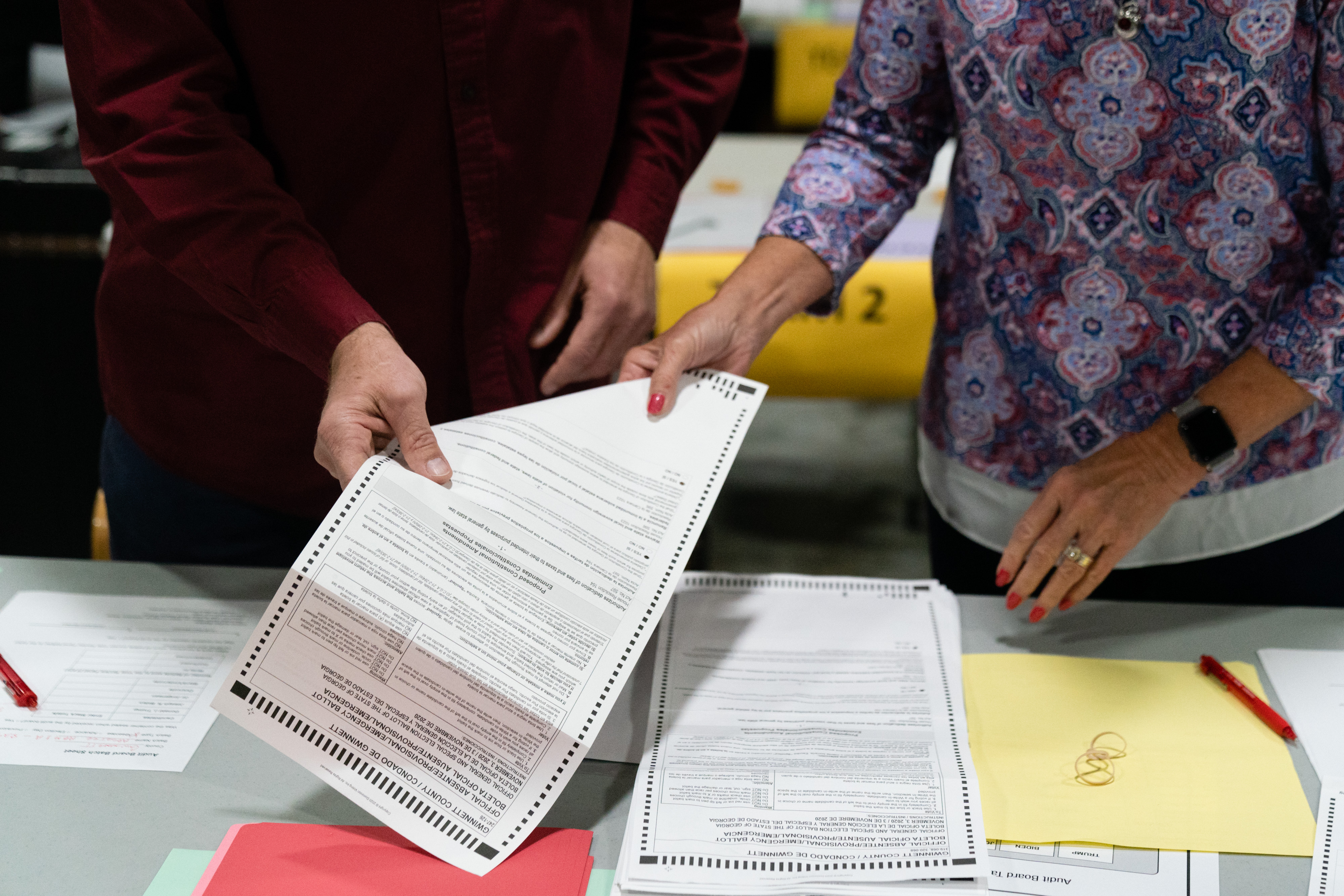 An election ballot is being handed from one person to another.