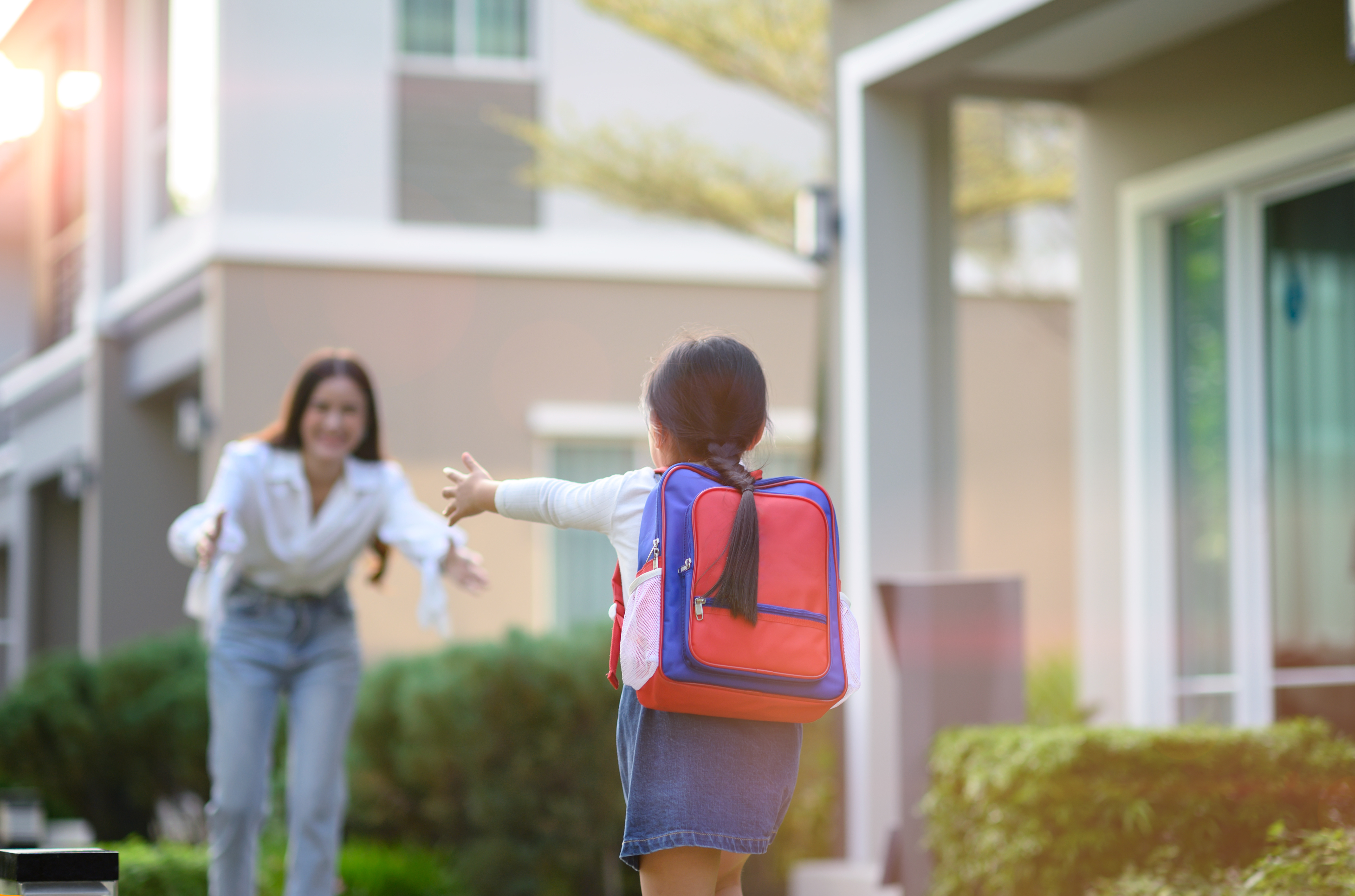 Little girl running to meet her mom after school