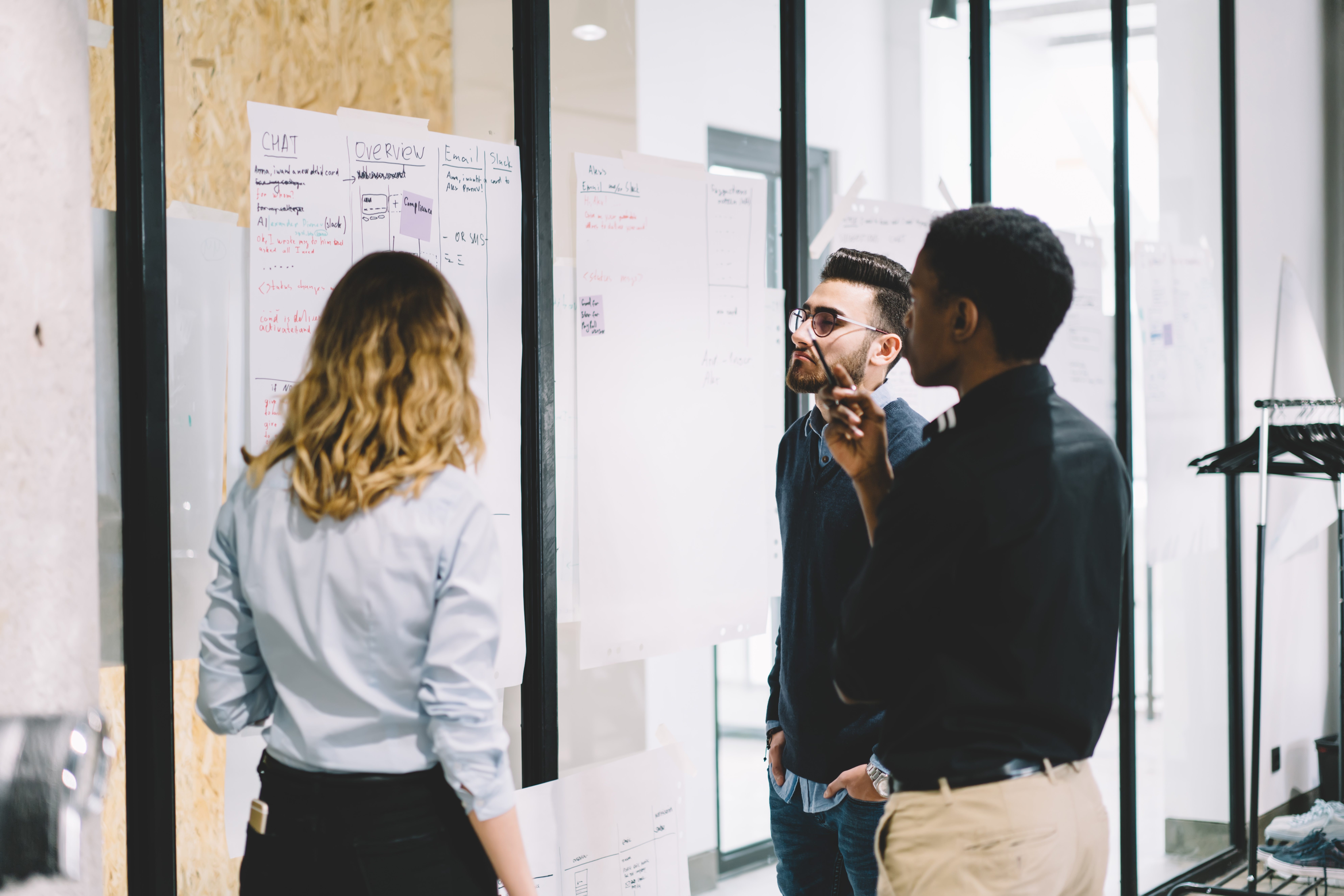 Employees looking at papers on wall