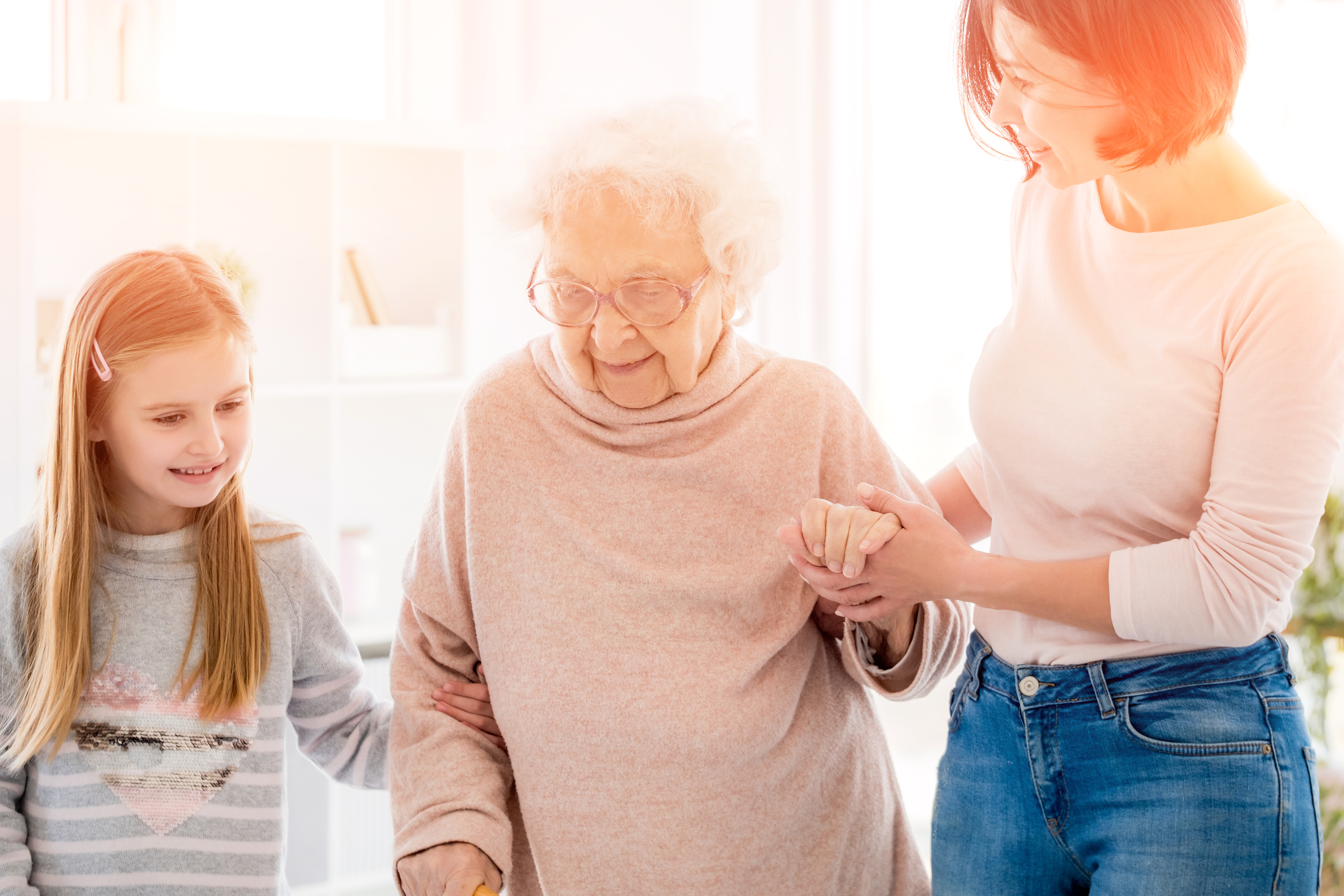 Woman and her daughter helping grandmother balance holding hand