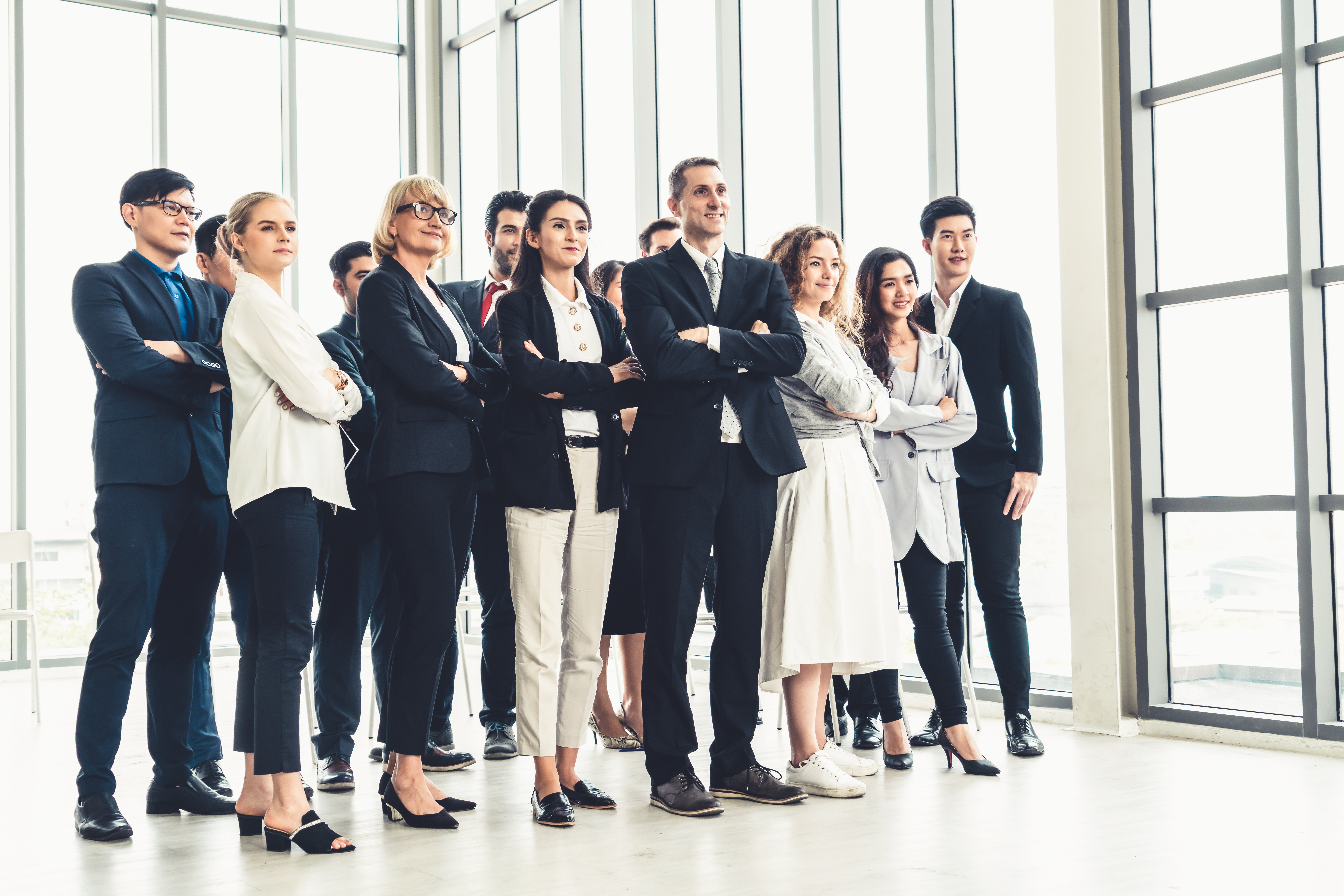 Diverse group of employees standing with arms crossed in office