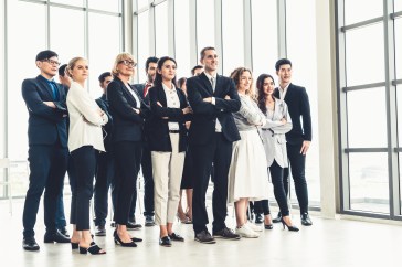 Diverse group of employees standing with arms crossed in office