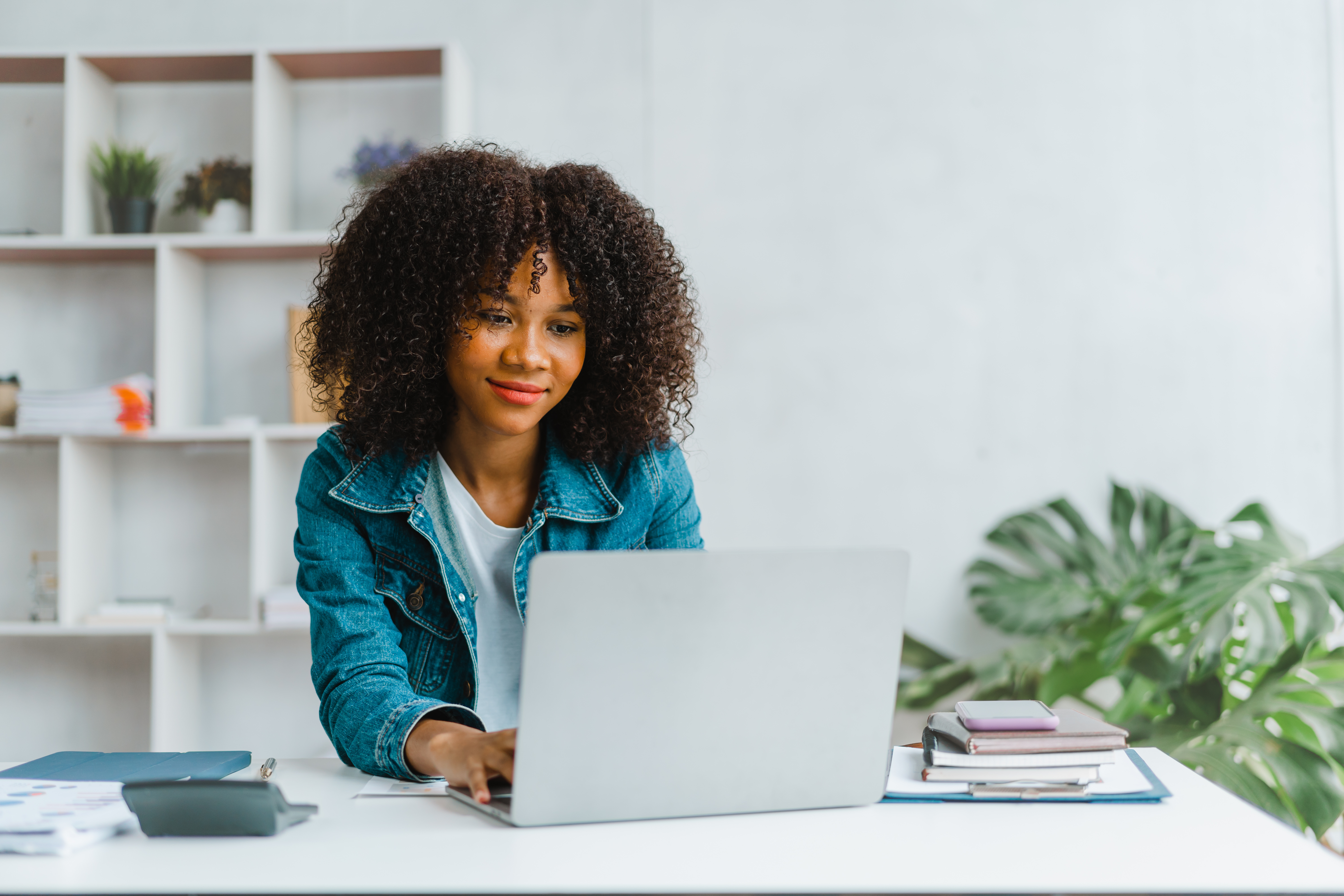 Woman smiling, looking at laptop