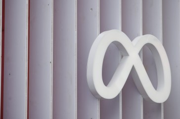 Meta logo (a white infinity loop) on the side of a paneled building.