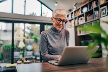 Woman working at counter at home on computer