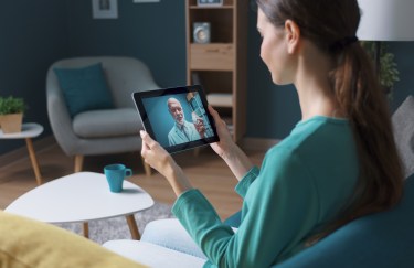 Woman using tablet for telehealth appointment with doctor