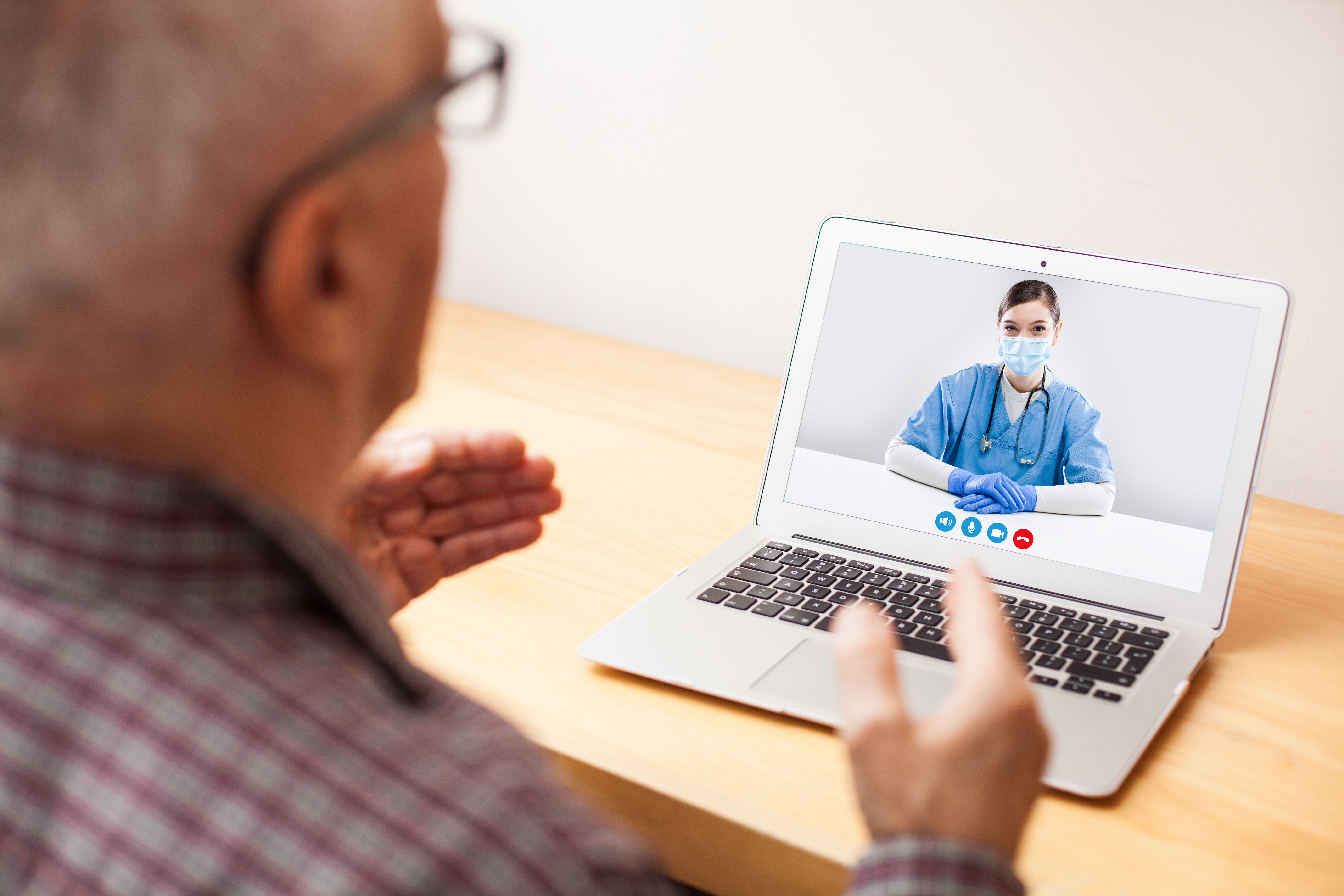 Elderly man using computer to speak with doctor