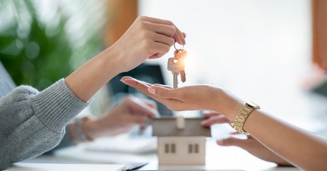 Person handing housekeys to woman with open hand