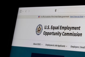 The EEOC's web page is visible only at the top of the computer screen.