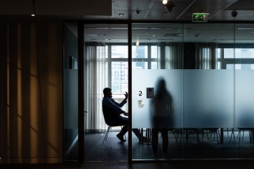 Two people sit in a conference room.