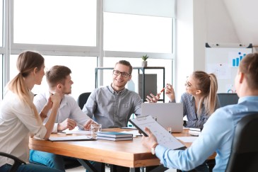 Group of employees sitting at table working