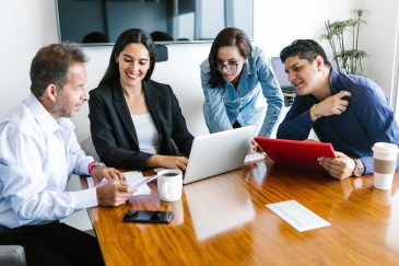 Group of employees working with laptop and tablet