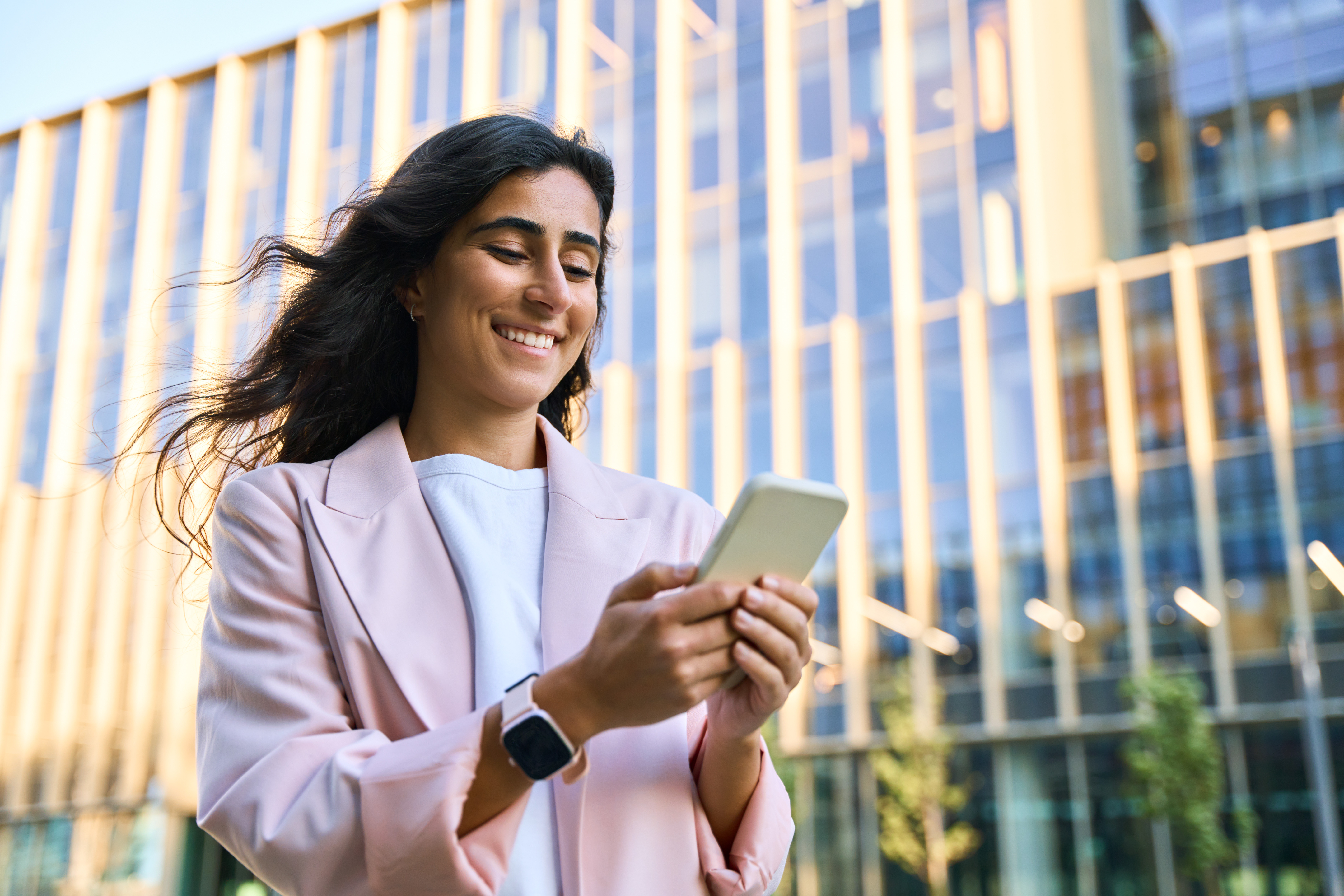 Young women in business casual looking at phone