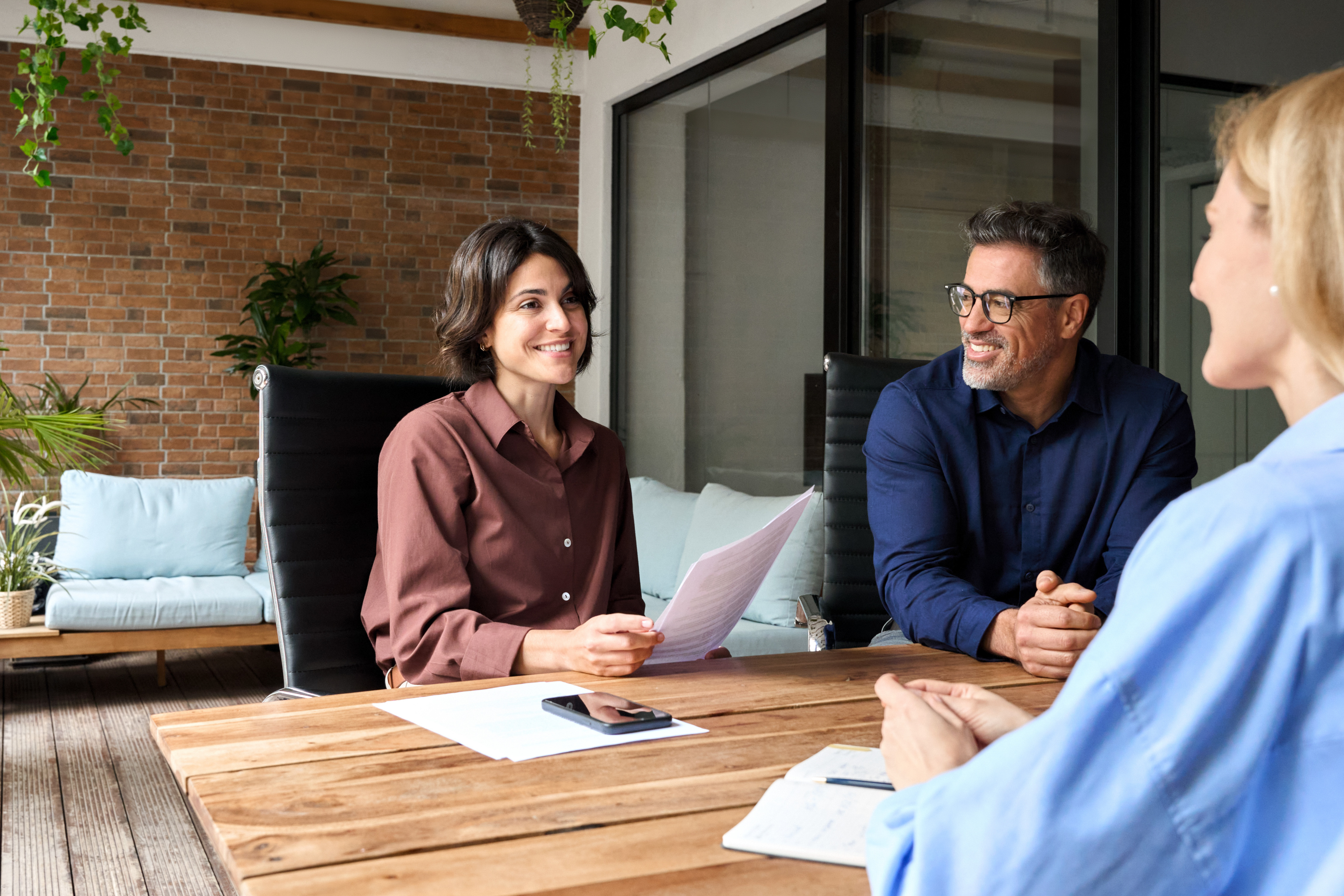 Employees talking around table, smiling