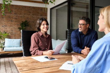 Employees talking around table, smiling