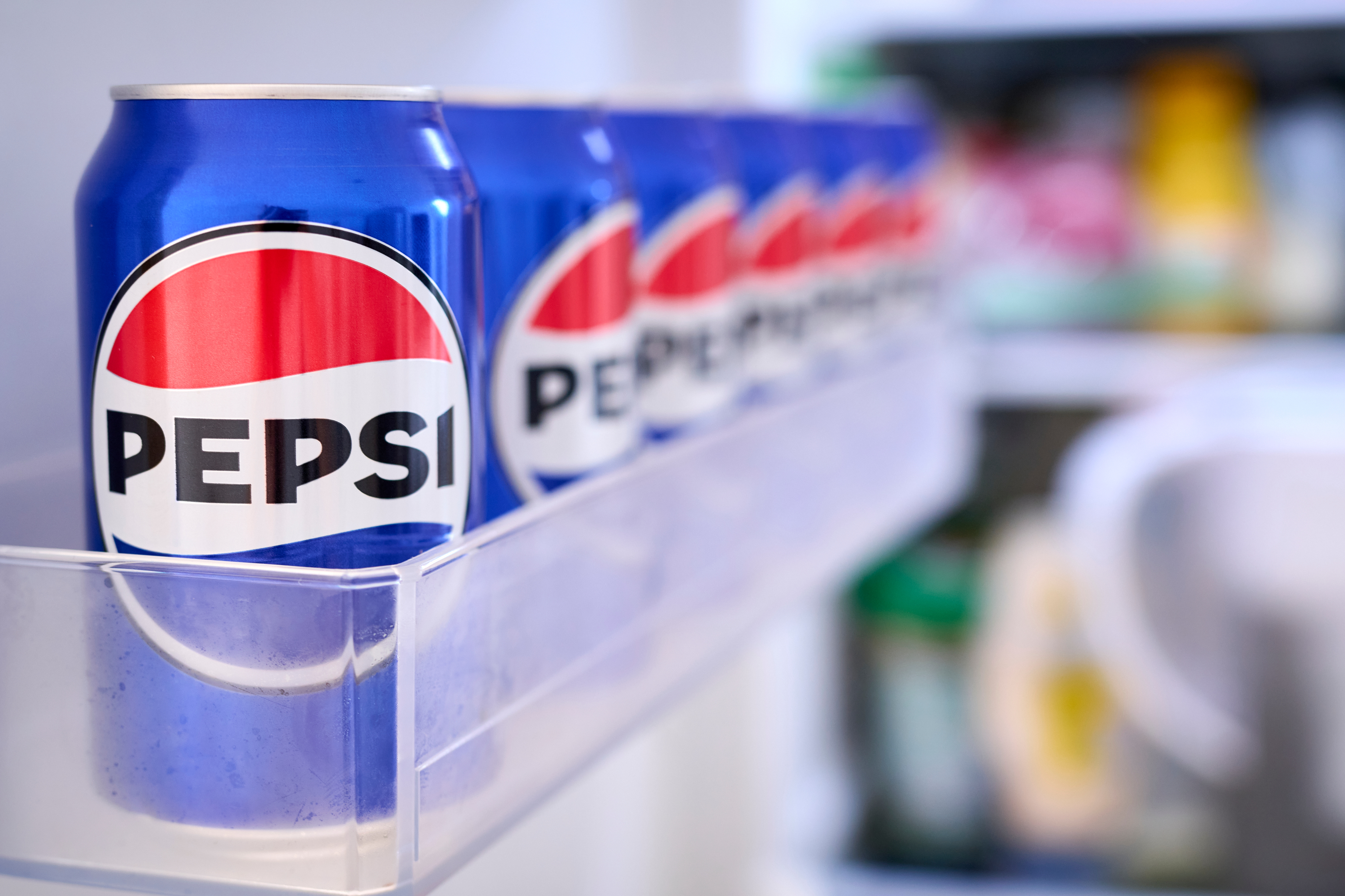 Row of Pepsi soda cans in a refrigerator